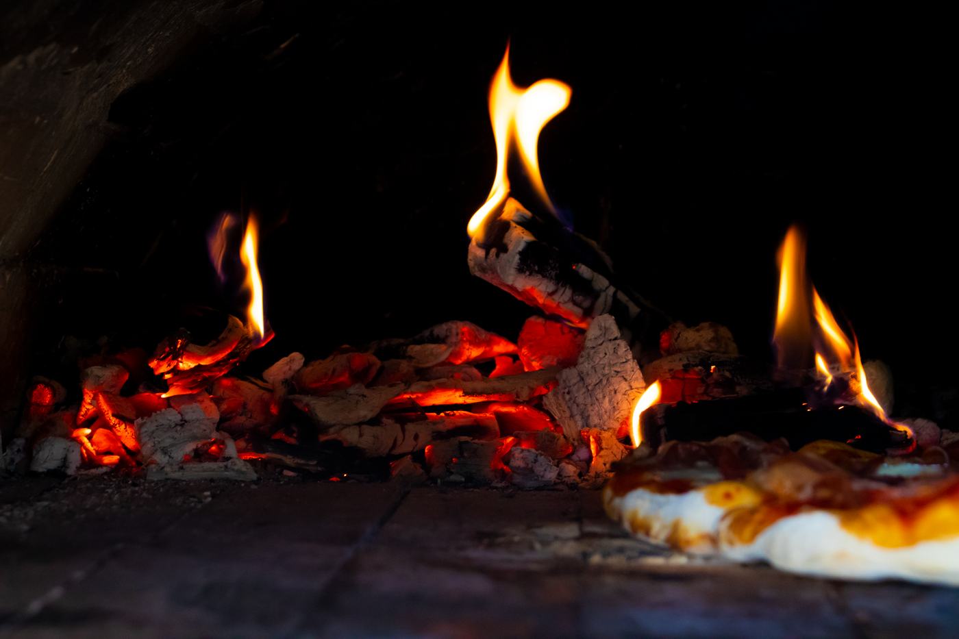 Glödande eld i pizzaugnen